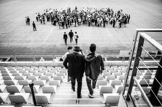 Hommes qui descendent l'escalier d'un stade pour rejoindre le groupe sur le stade