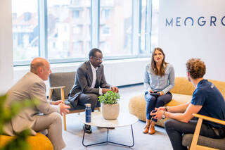 MEOGROUP team gathered for a discussion in a workspace